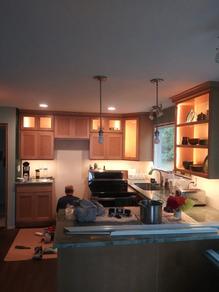 Warm wood kitchen remodel with pendant lights and illuminated cabinets