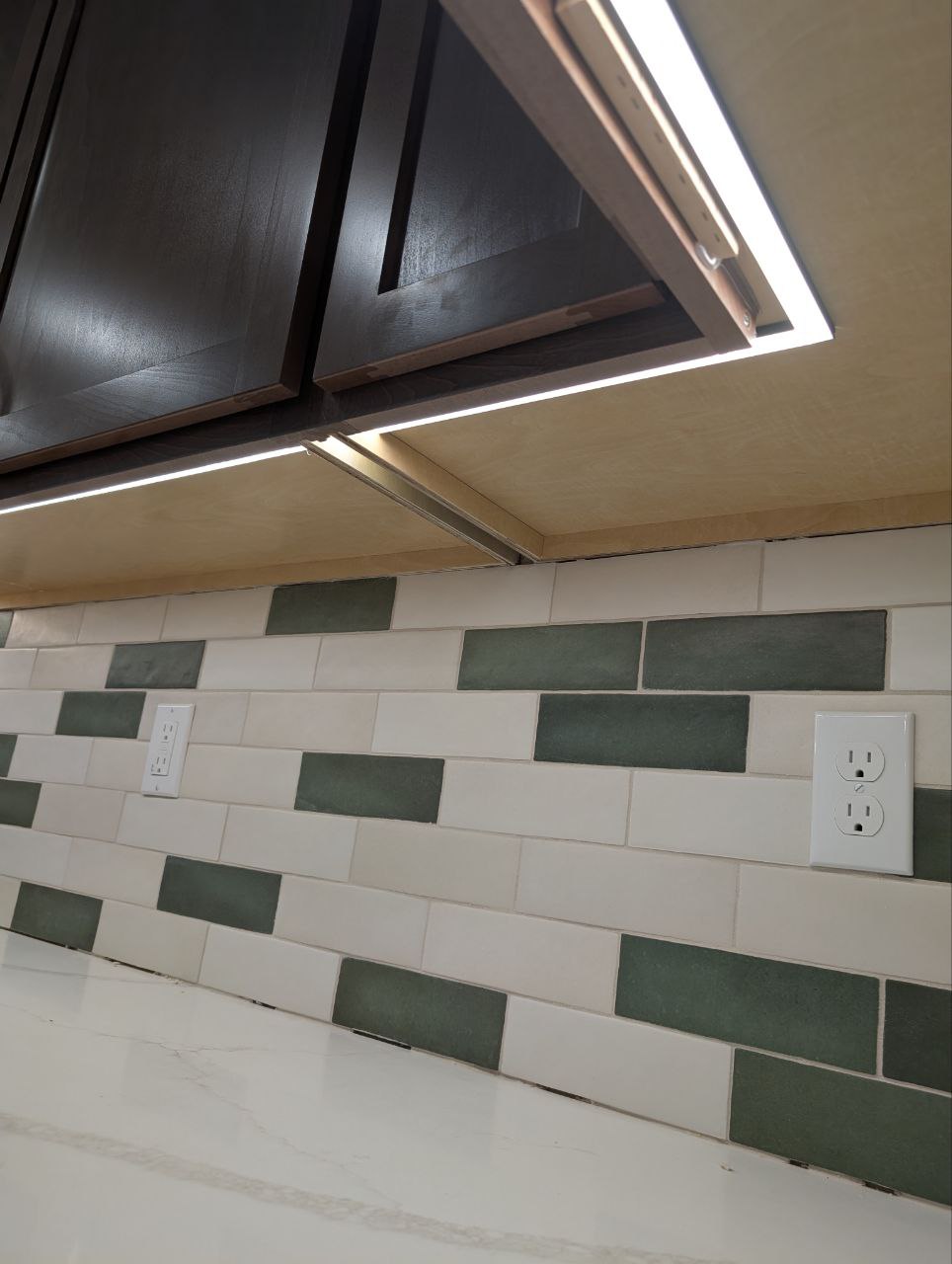 Under-cabinet lighting and countertop receptacles above a tiled backsplash