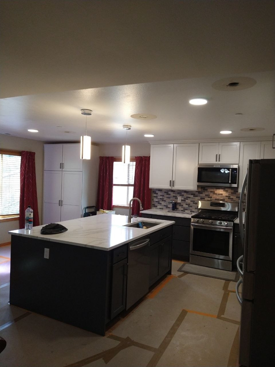Kitchen island with pendant and recessed lighting, with finishing work still in progress
