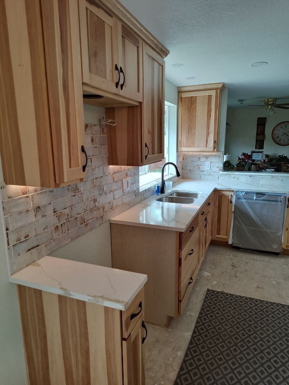 Wood-cabinet kitchen with under-cabinet lighting during finishing work
